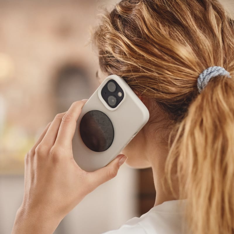 Smartphone mit angebrachtem Beyond Matter-Chip Ava für EMF-Schutz bei mobilen Endgeräten.