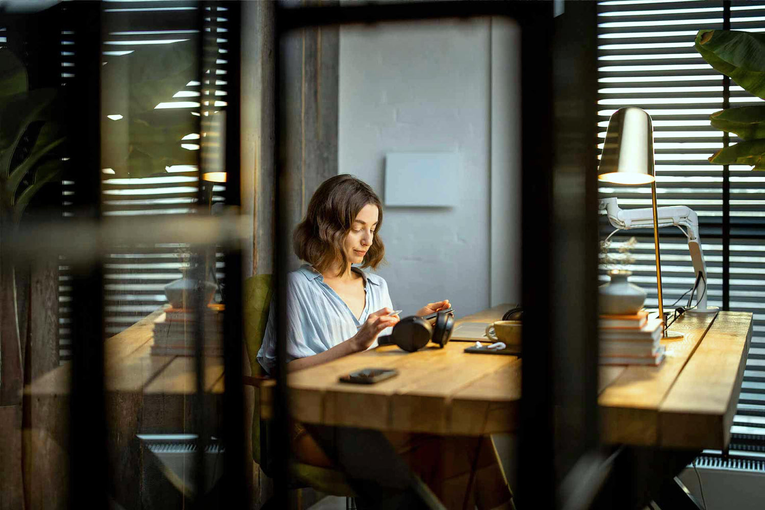 Frau arbeitet konzentriert an einem Schreibtisch mit elektronischen Geräten – moderne Arbeitsumgebung mit Elektrosmog im Alltag.