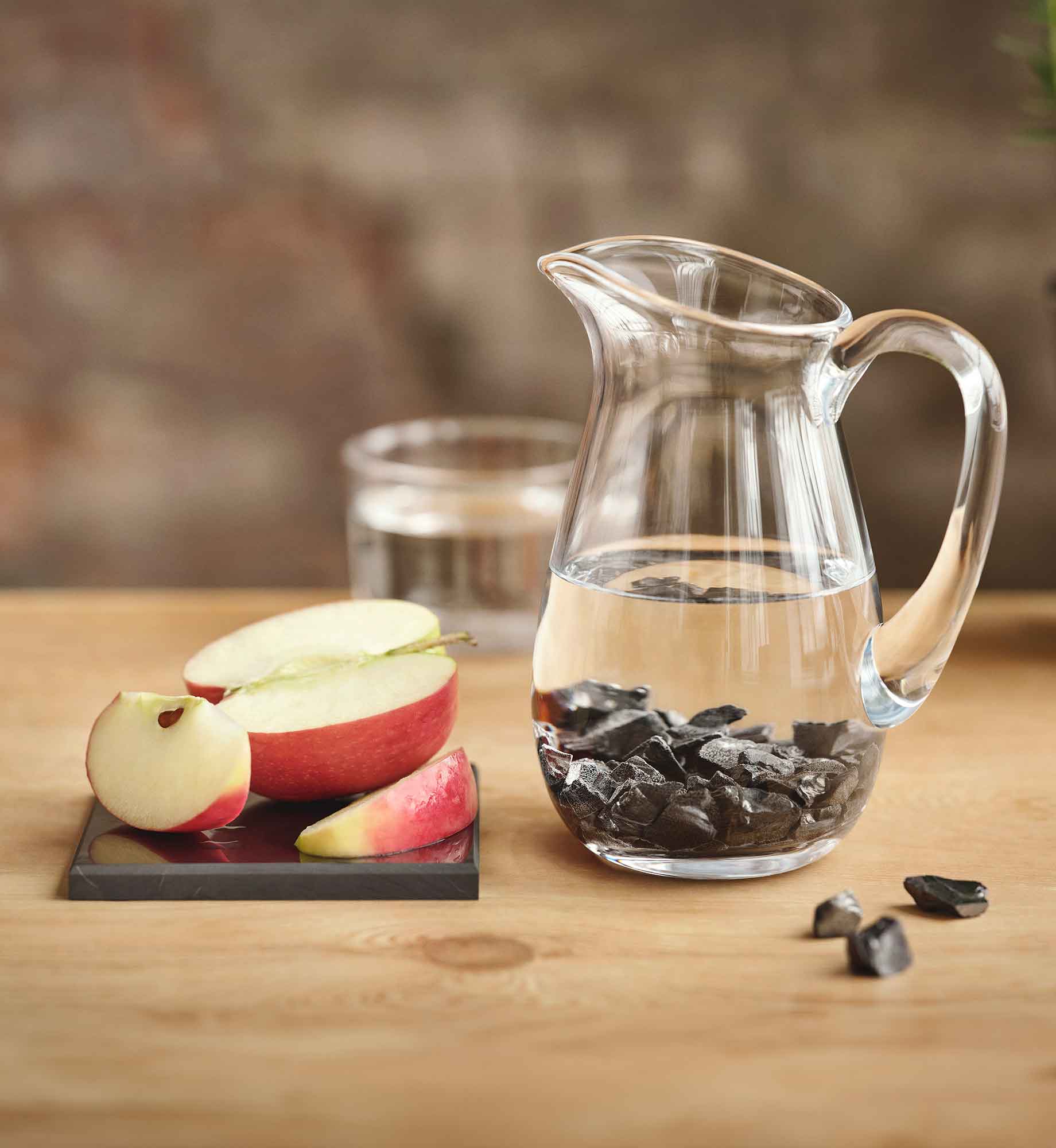 Steine Arielle aus EssenceX-Edelschungit von Beyond Matter in einem mit Wasser befüllten Wasserkrug.