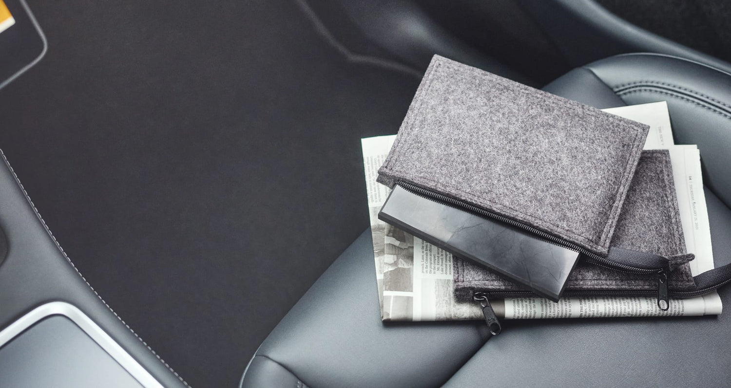 Platten Max aus EssenceX-Schungit von Beyond Matter mit Filz-Etui im Fahrzeuginnenraum.