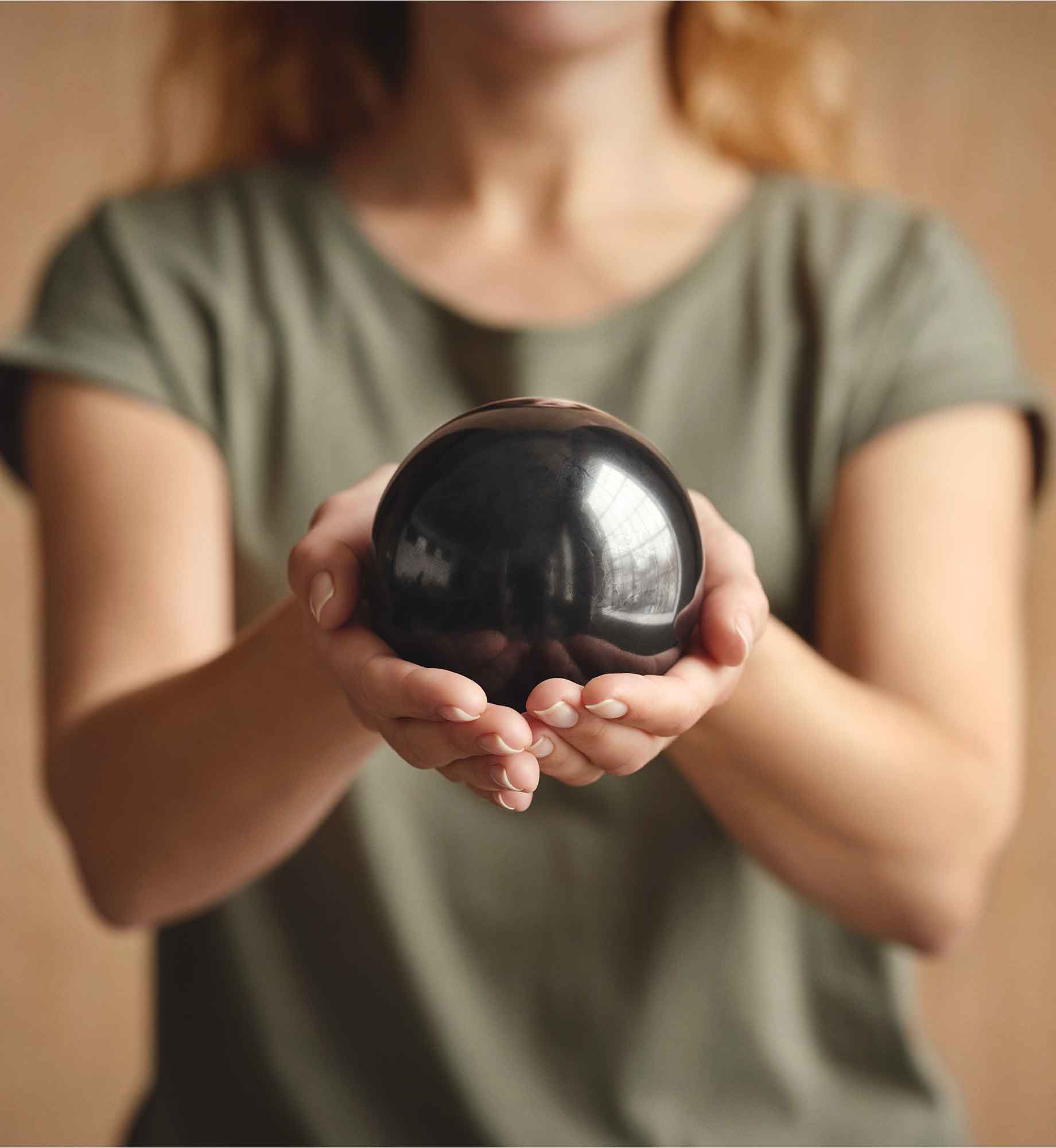 Kugel Samson aus EssenceX-Schungit von Beyond Matter als Objekt in den Händen gehalten.