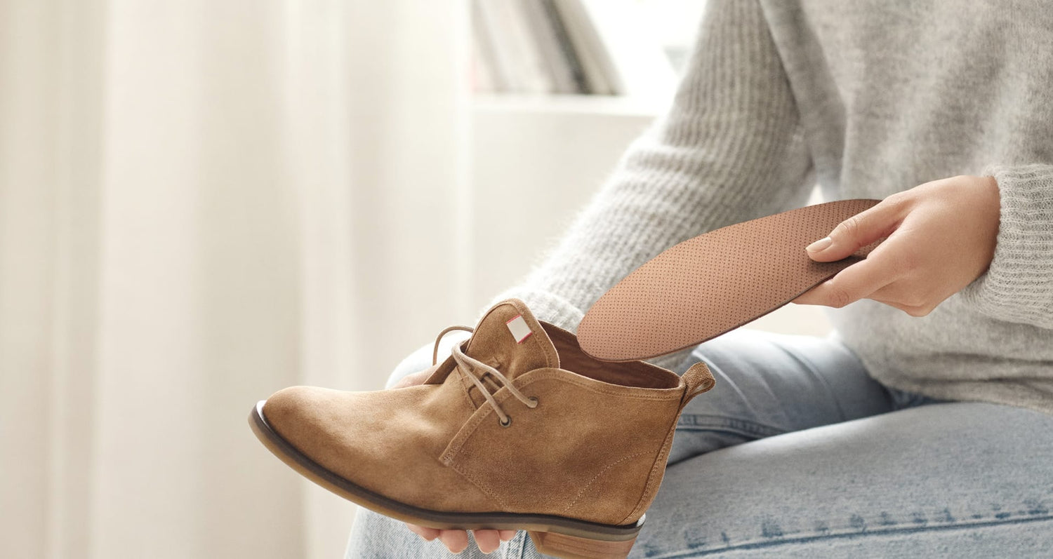 Anwendungsszene der Tom Einlegesohlen von Beyond Matter beim Einlegen in einen Schuh.
