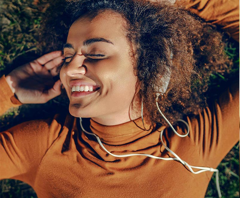 Frau nutzt ihr Smartphone in natürlicher Umgebung – Sinnbild für Natürlichkeit und bewusstes Leben.