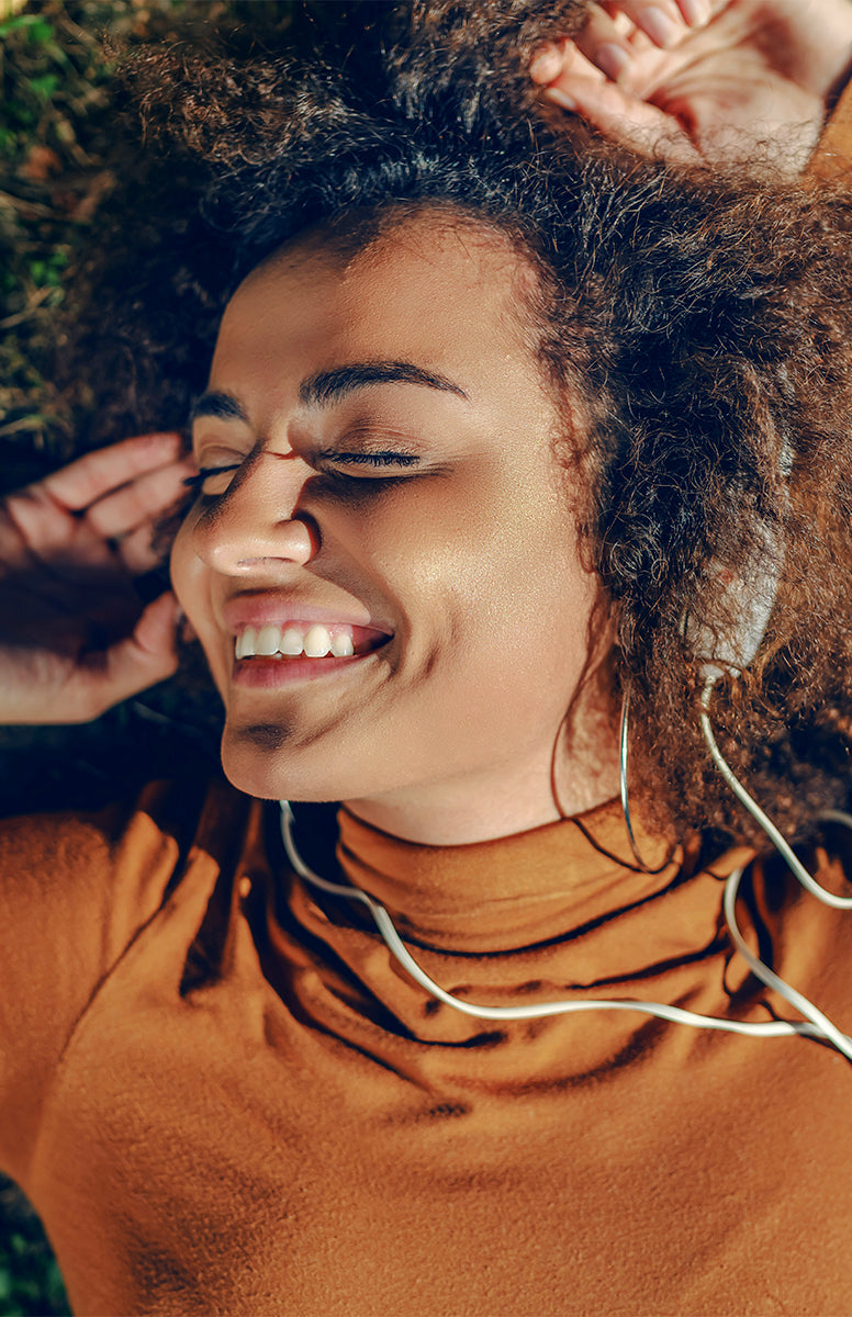 Frau nutzt ihr Smartphone in natürlicher Umgebung – Sinnbild für Natürlichkeit und bewusstes Leben.