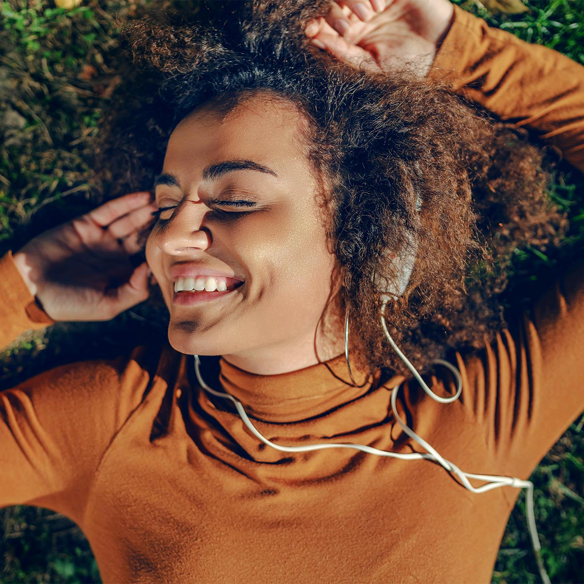 Frau nutzt ihr Smartphone in natürlicher Umgebung – Sinnbild für Natürlichkeit und bewusstes Leben.