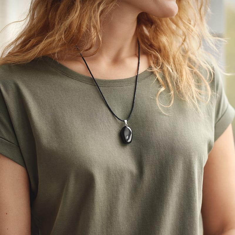 Person trägt Beyond Matter-Anhänger Luma am Körper – EMF-Schutz für Menschen im Alltag.