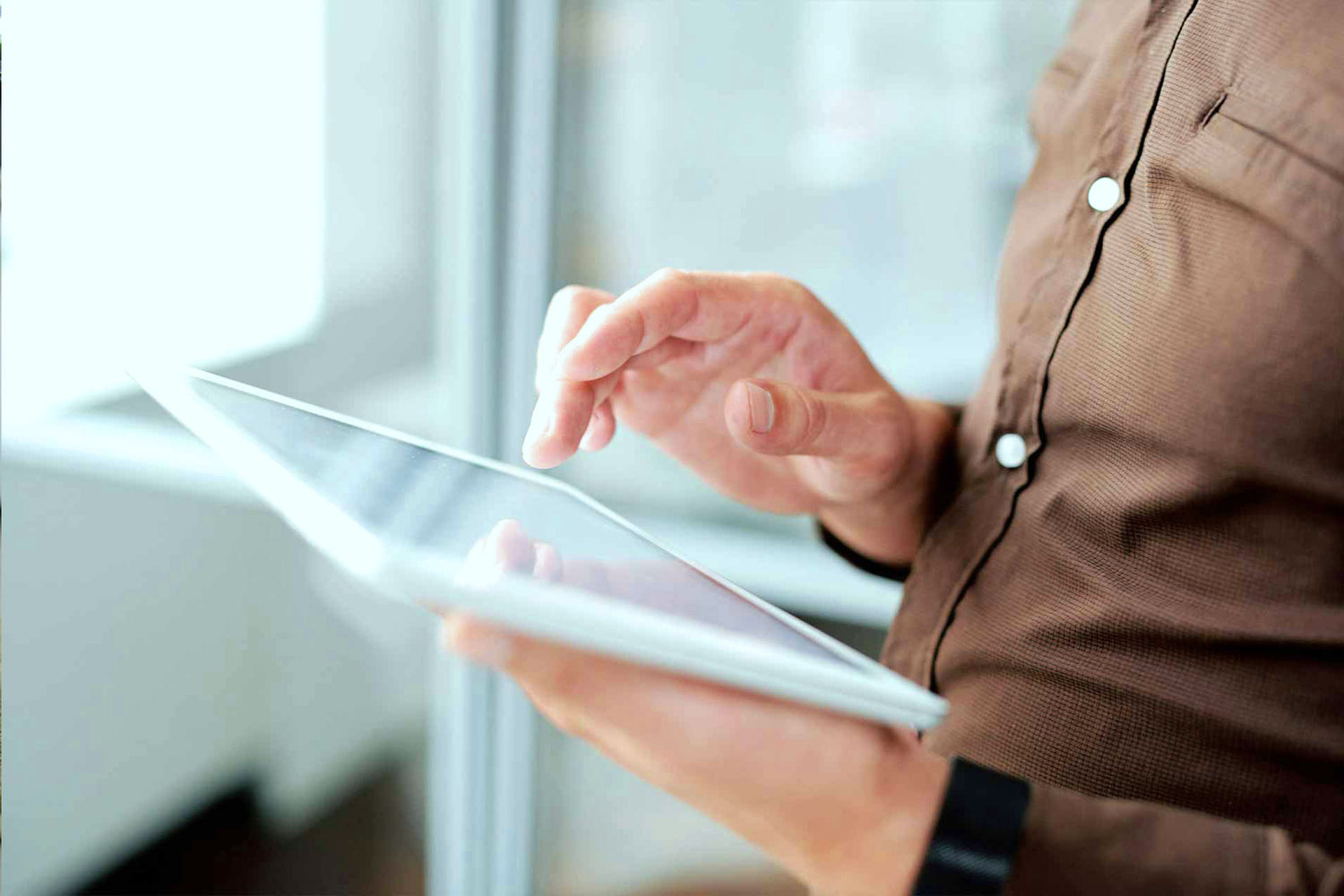 Person nutzt ein Tablet im Innenraum – Sinnbild für Beschäftigung mit Informationen.