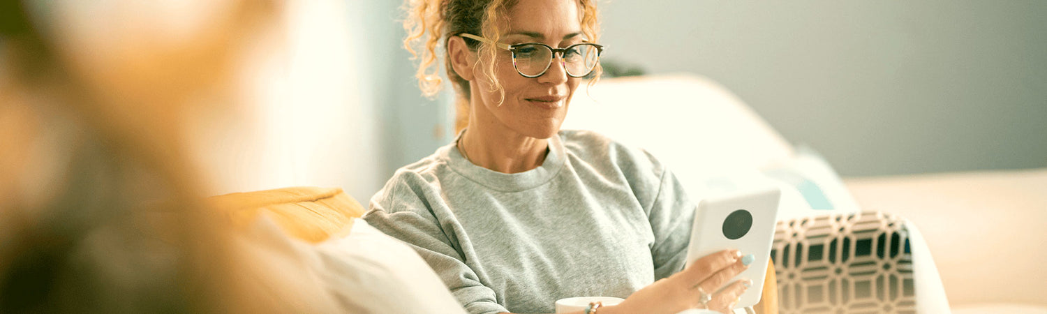 Frau liest entspannt auf dem Smartphone – Sinnbild für Wissen, Orientierung und verständliche Informationen zu Elektrosmog.