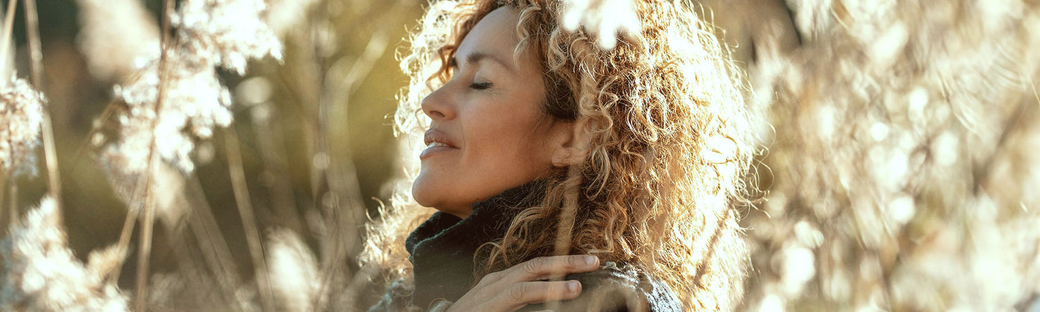 Frau mit geschlossenen Augen in der Natur – Sinnbild für Achtsamkeit, Haltung und die Vision von Beyond Matter.