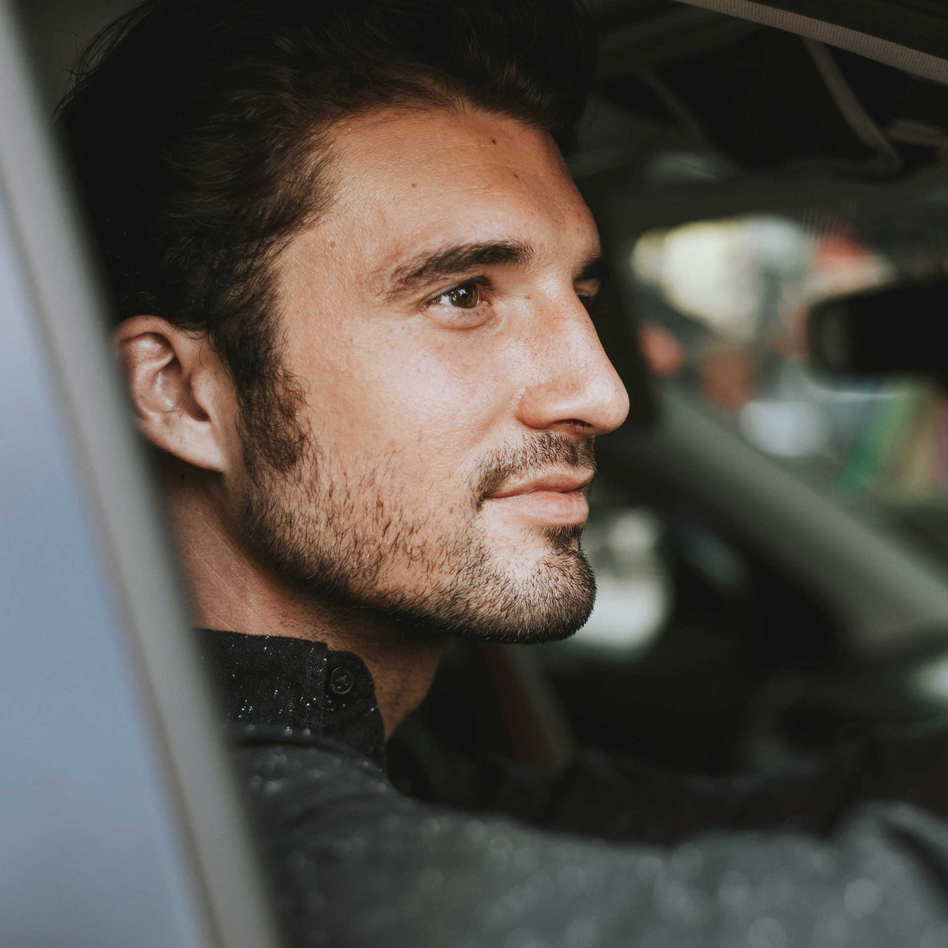 Entspannter Mann am Steuer – Sinnbild für fokussiertes und gelassenes Autofahren.