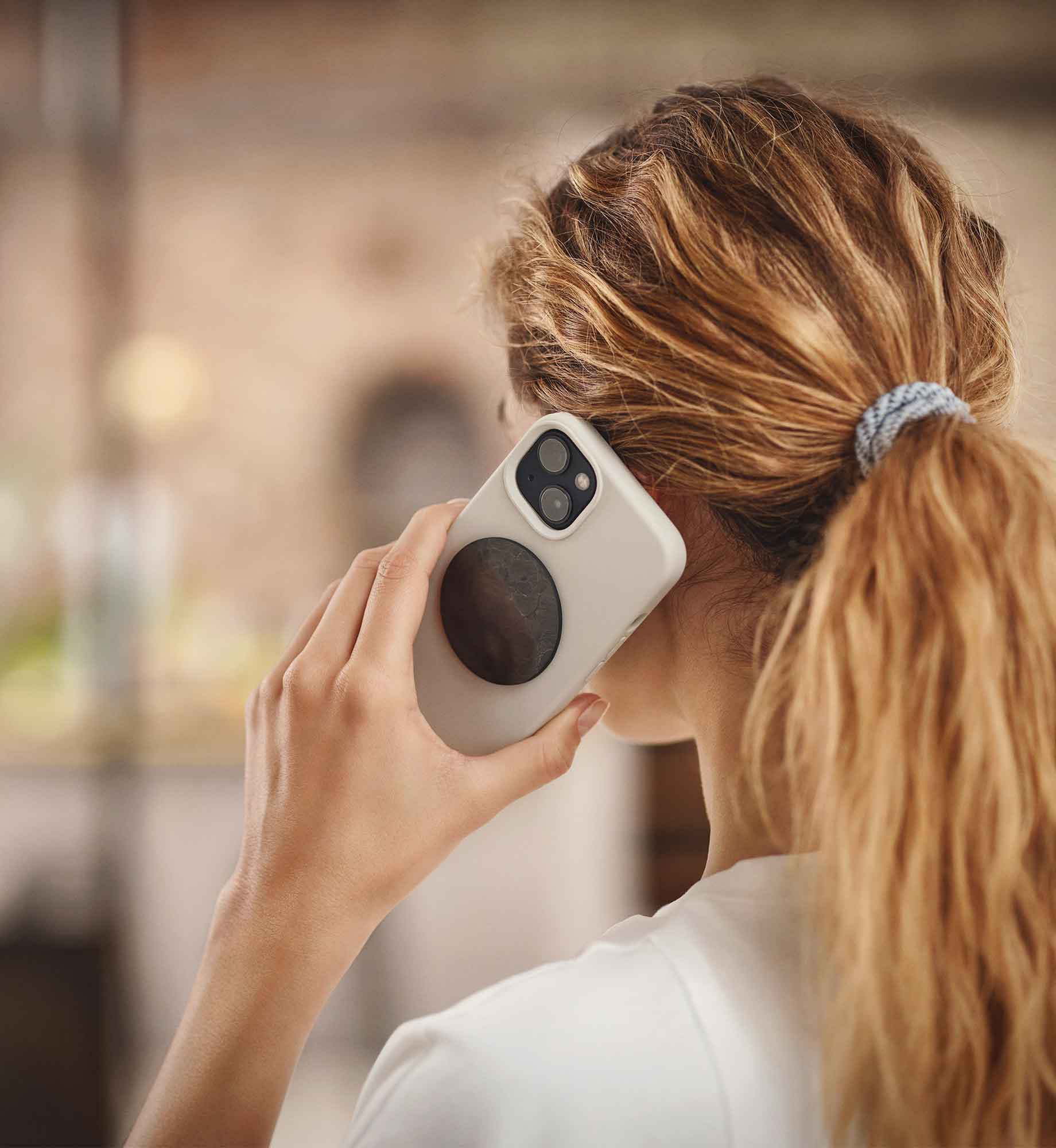 Chip Ava aus EssenceX-Schungit von Beyond Matter auf der Rückseite eines Smartphones angebracht.