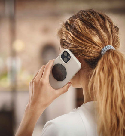 Chip Ava aus EssenceX-Schungit von Beyond Matter auf der Rückseite eines Smartphones angebracht.