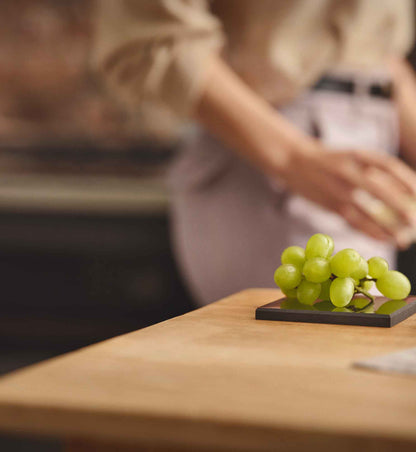 Platte Lotte aus EssenceX-Schungit von Beyond Matter unter Lebensmitteln in einer Küche.