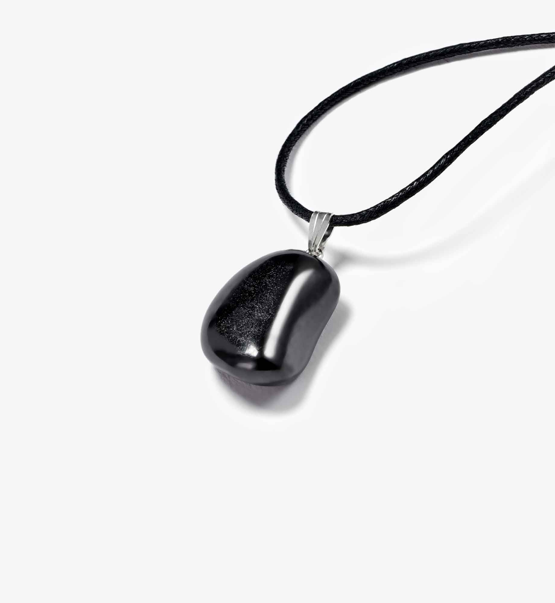 Liegende Produktansicht des Anhängers Luma aus geschliffenem EssenceX-Schungit von Beyond Matter – mit natürlicher Struktur und roher Oberfläche.