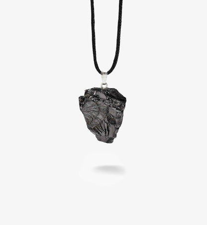 Anhänger Sol aus ungeschliffenem EssenceX-Edelschungit von Beyond Matter auf hellem Hintergrund.