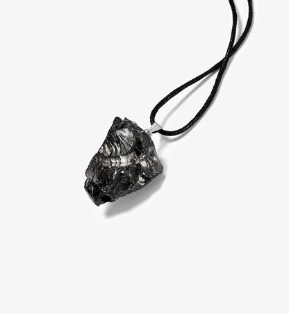 Liegende Produktansicht des Anhängers Sol aus ungeschliffenem EssenceX-Edelschungit von Beyond Matter – mit natürlicher Struktur und roher Oberfläche.