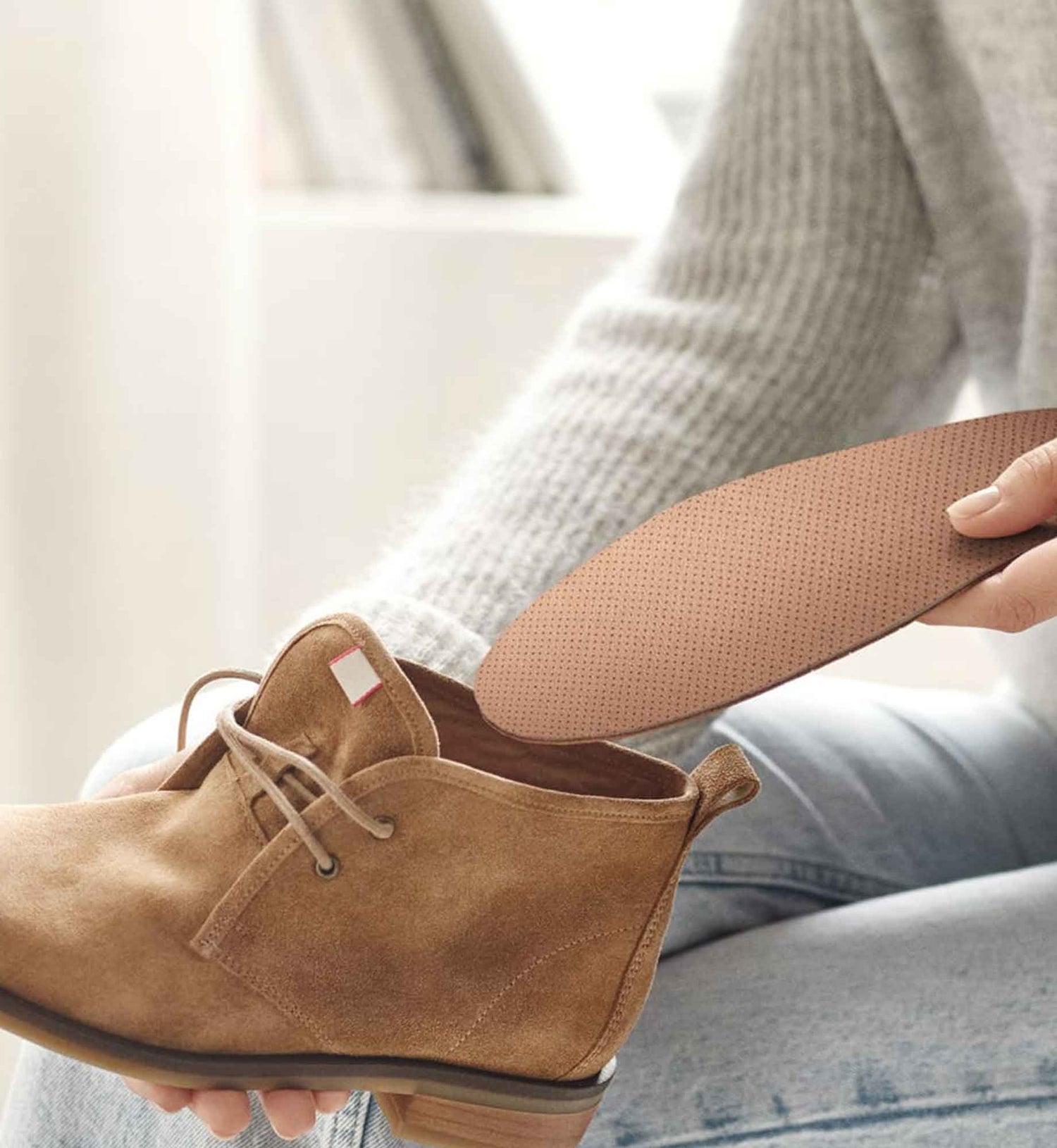 Anwendungsszene der Tom Einlegesohlen von Beyond Matter beim Einlegen in einen Schuh.