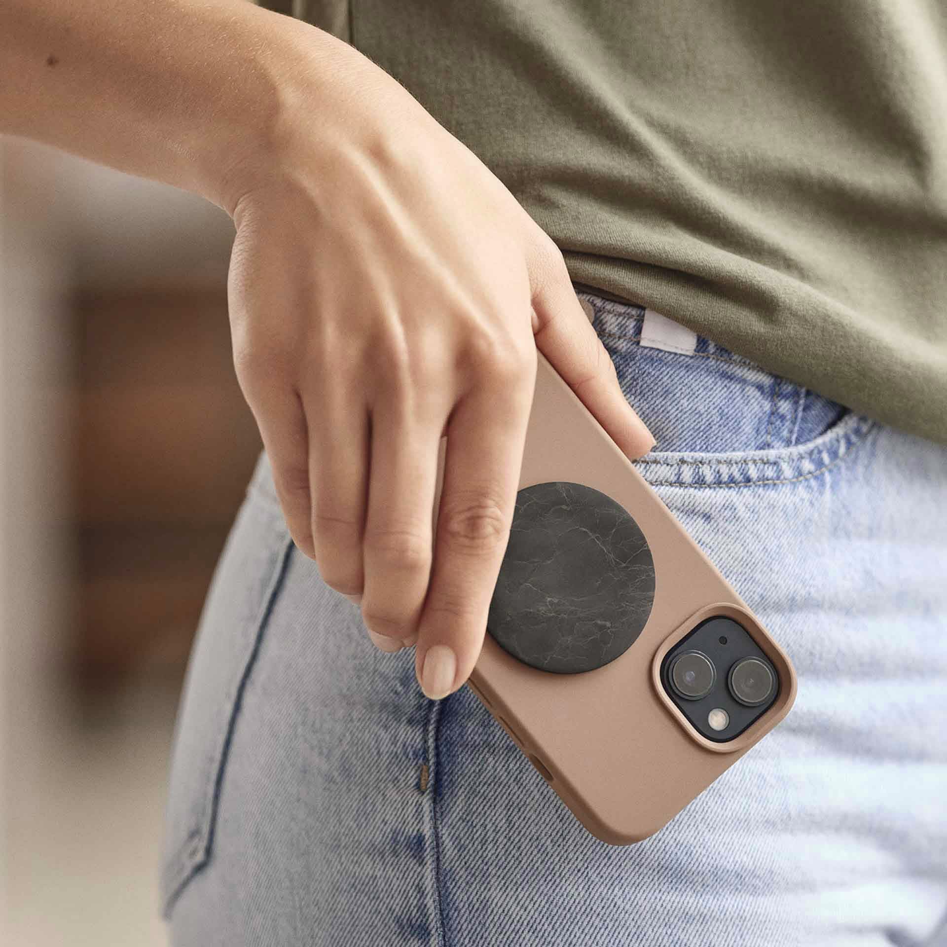 Smartphone in der Hand mit angebrachtem EMF-Chip – Anwendung im mobilen Alltag.