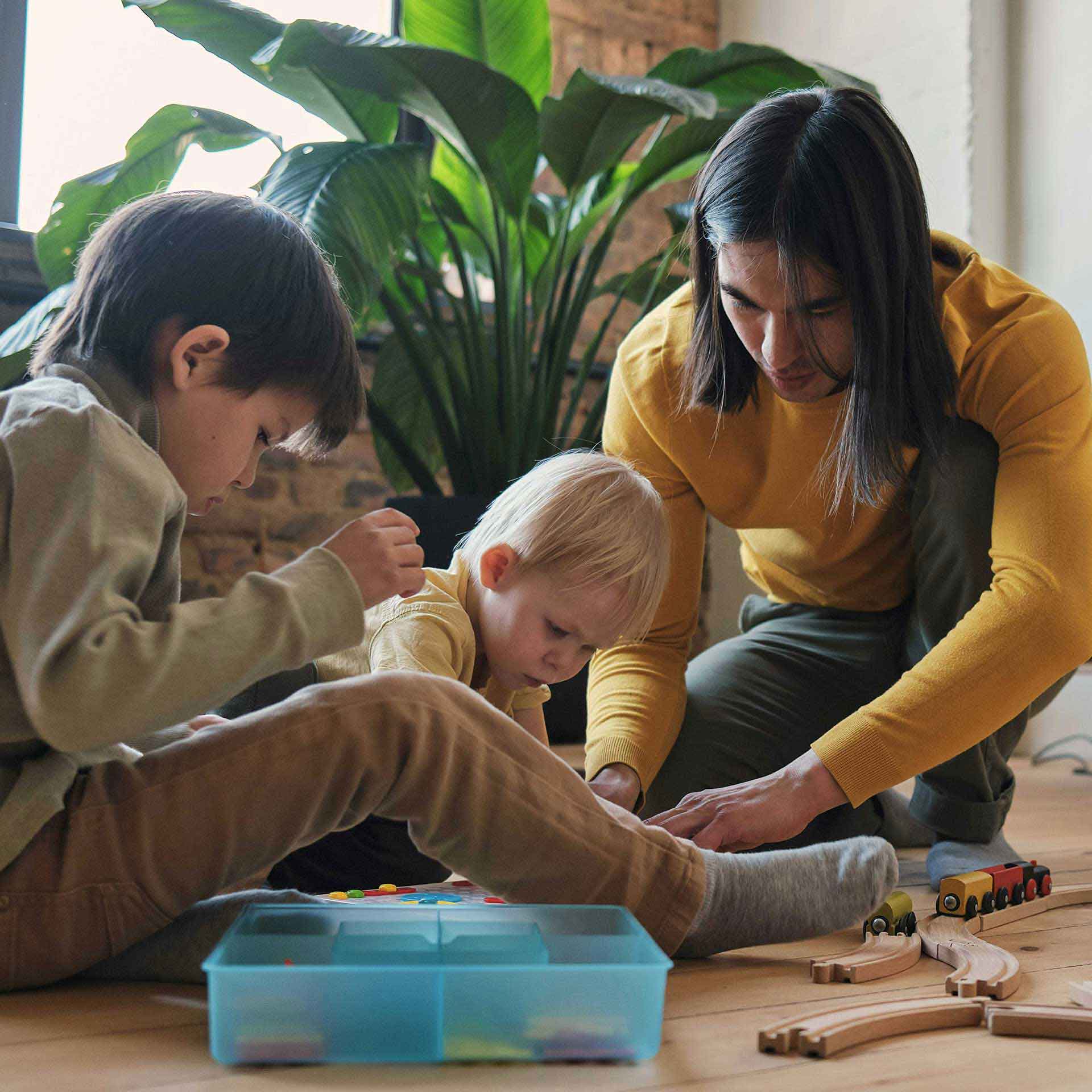 Familie spielt gemeinsam zuhause – Sinnbild für Schutz, Nähe und einen entspannten Alltag.