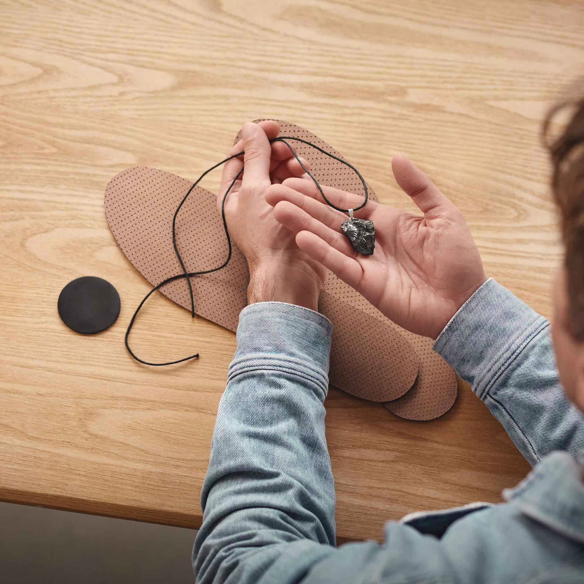 Hände halten mehrere EMF-Schutzprodukte – Vorbereitung für einen ganzheitlichen Schutz im Alltag.