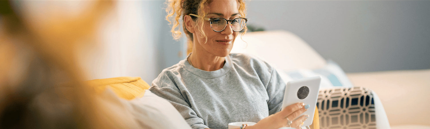 Frau mit Tablet sitzend – Sinnbild für Wissen, Orientierung und verständliche Informationen zu Elektrosmog.