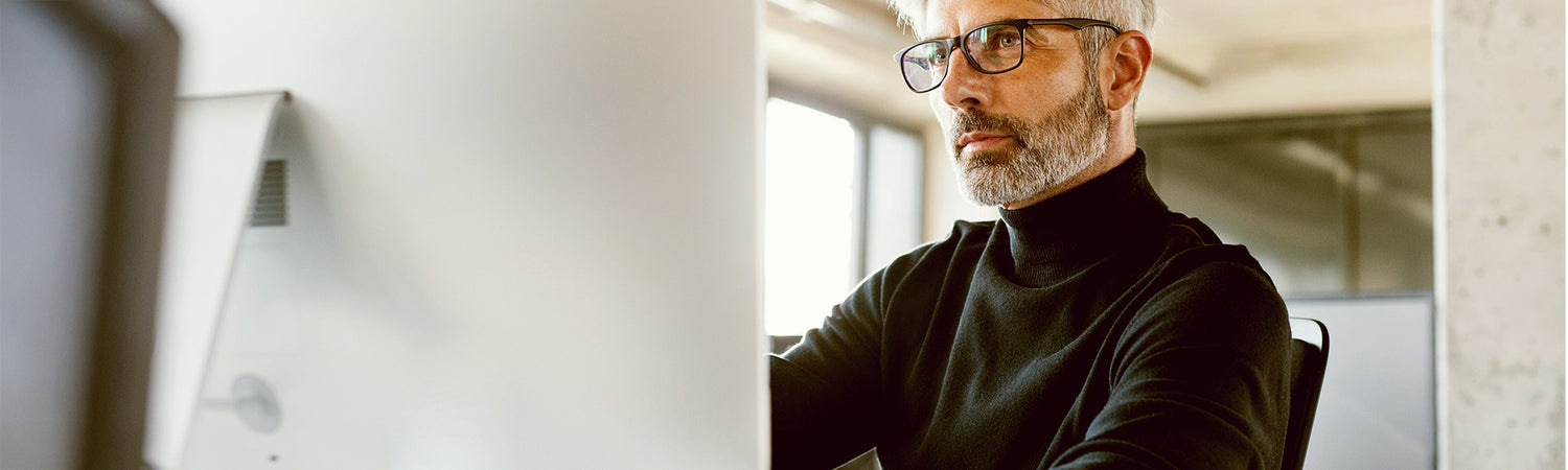 Mann vor Rechner sitzend – Sinnbild für Vertrauen, Forschung und Wissenschaft bei Beyond Matter.